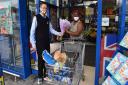 Store manager Chris Pawson presents a bouquet of flowers to the first customer through the door Olukemi Adebayo.