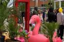 A giant, inflatable pink flamingo perches in the middle of the shopping arcade as the film crew gets to work.
