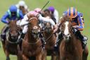 Ryan Moore riding Love (right, blue/orange) to victory in the Qipco 1000 Guineas Stakes at Newmarket Racecourse