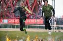 Recorder news editor Freddy Mayhew and reporter Mark Shales cross the final firey obstacle. Picture: Reebok Spartan Race UK