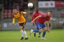 Dagenham & Redbridge captain Matt Robinson battles for the ball against Woking