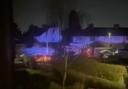 Blue lights from police cars lit up Langley Gardens