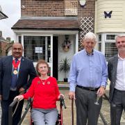 Trevor and Doreen Lock with councillors Peter Chand and Dominic Twomey outside their home, with the plaque in their honour visible above the door.