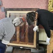 Sarah Cove (left) inspects the back of one of the Fanshawe paintings.