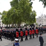 Members of the Royal Navy pull the State Gun Carriage carrying the coffin of Queen Elizabeth II, draped in the Royal Standard with the Imperial State Crown and the Sovereign's orb and sceptre, in the Ceremonial Procession during her State Funeral at