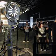 Director Toby Dare (back to camera) shows students how to set up lighting