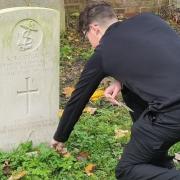 Student tends Commonwealth grave of First World War Royal Navy sailor in Dagenham churchyard who died aged 24